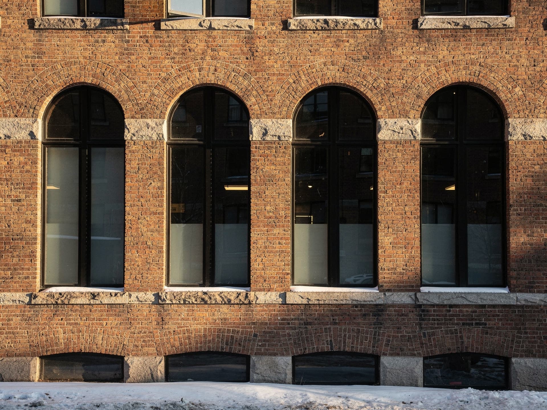 Amoskeag mill brick and its window rhythm in low winter sun.